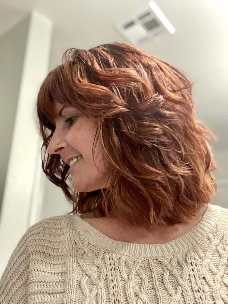 Shear Perfections 6 Left side view of Sharon’s Style — a layered bob hairstyle with vibrant red highlights from Shear Perfections salon